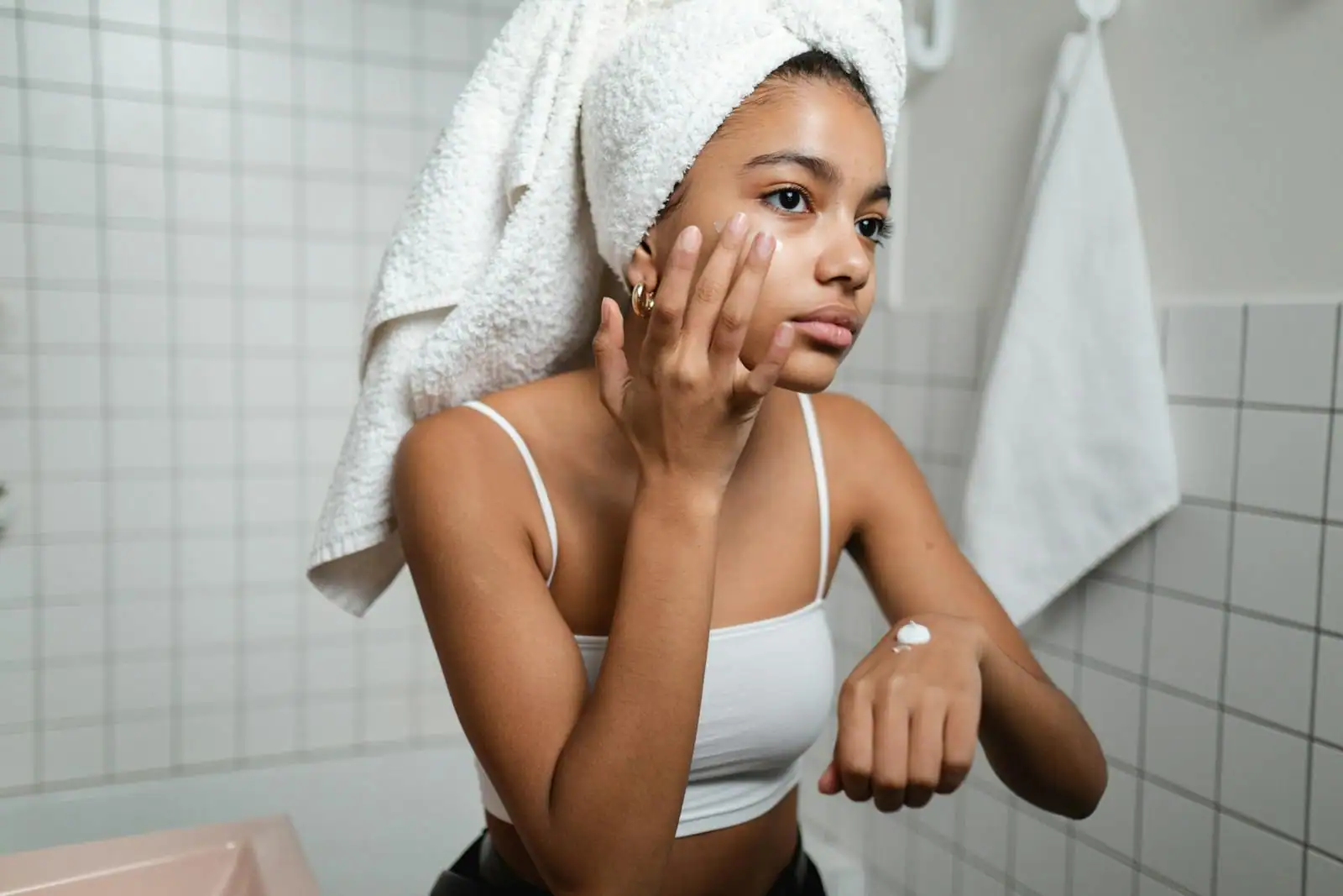 Application d'une crème hydratante sur le visage du bout des doigts