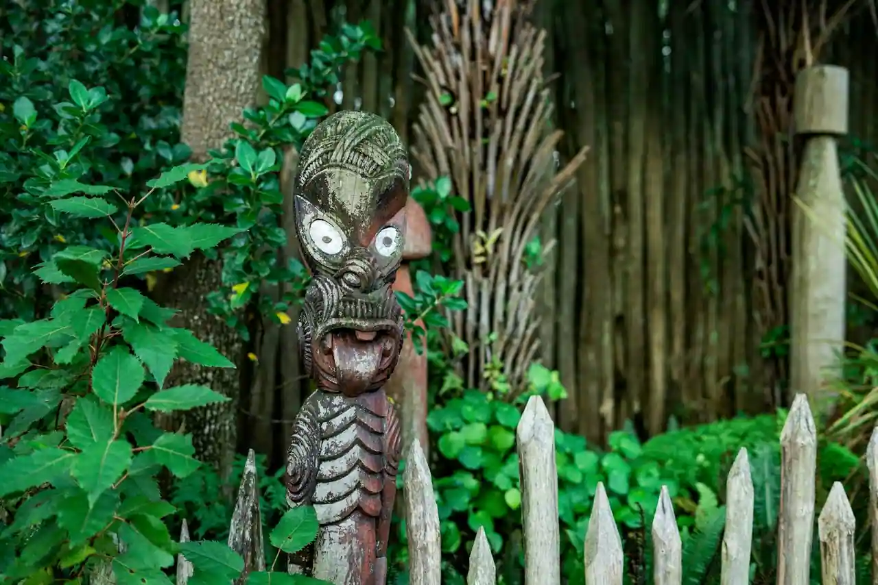 Maison de réunion maorie (marae) sculptée en bois sous un ciel néo-zélandais, symbole de la culture d'Aotearoa