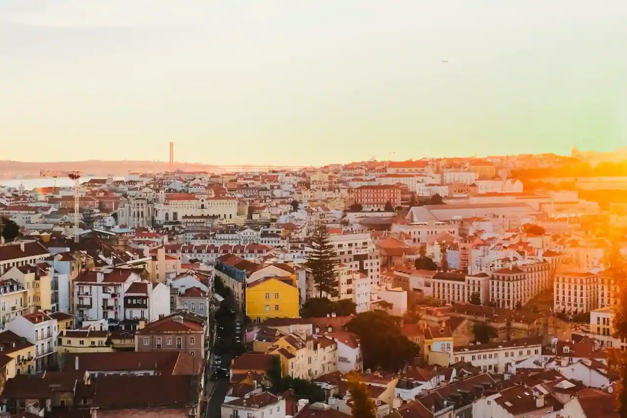 Terrasse rooftop d'un hôtel design avec vue sur les toits de Lisbonne au coucher du soleil