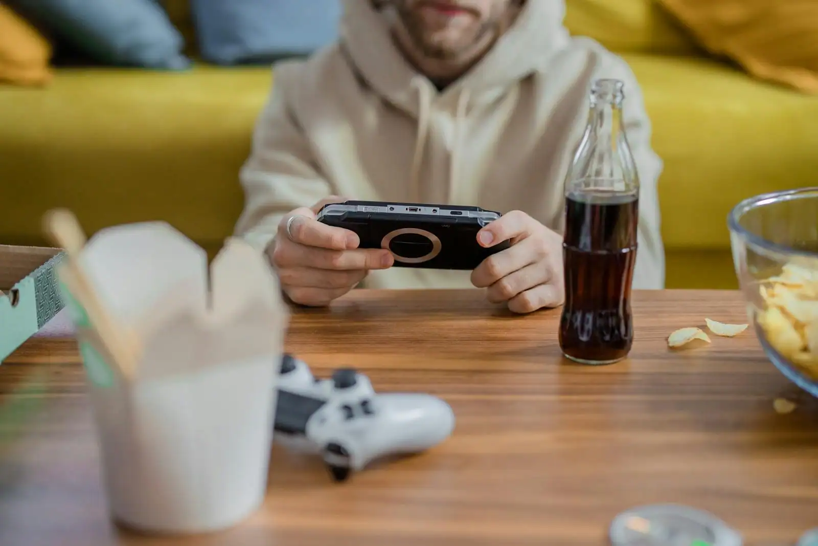 Jeune femme jouant à une console de jeu portable dans une ambiance lumineuse