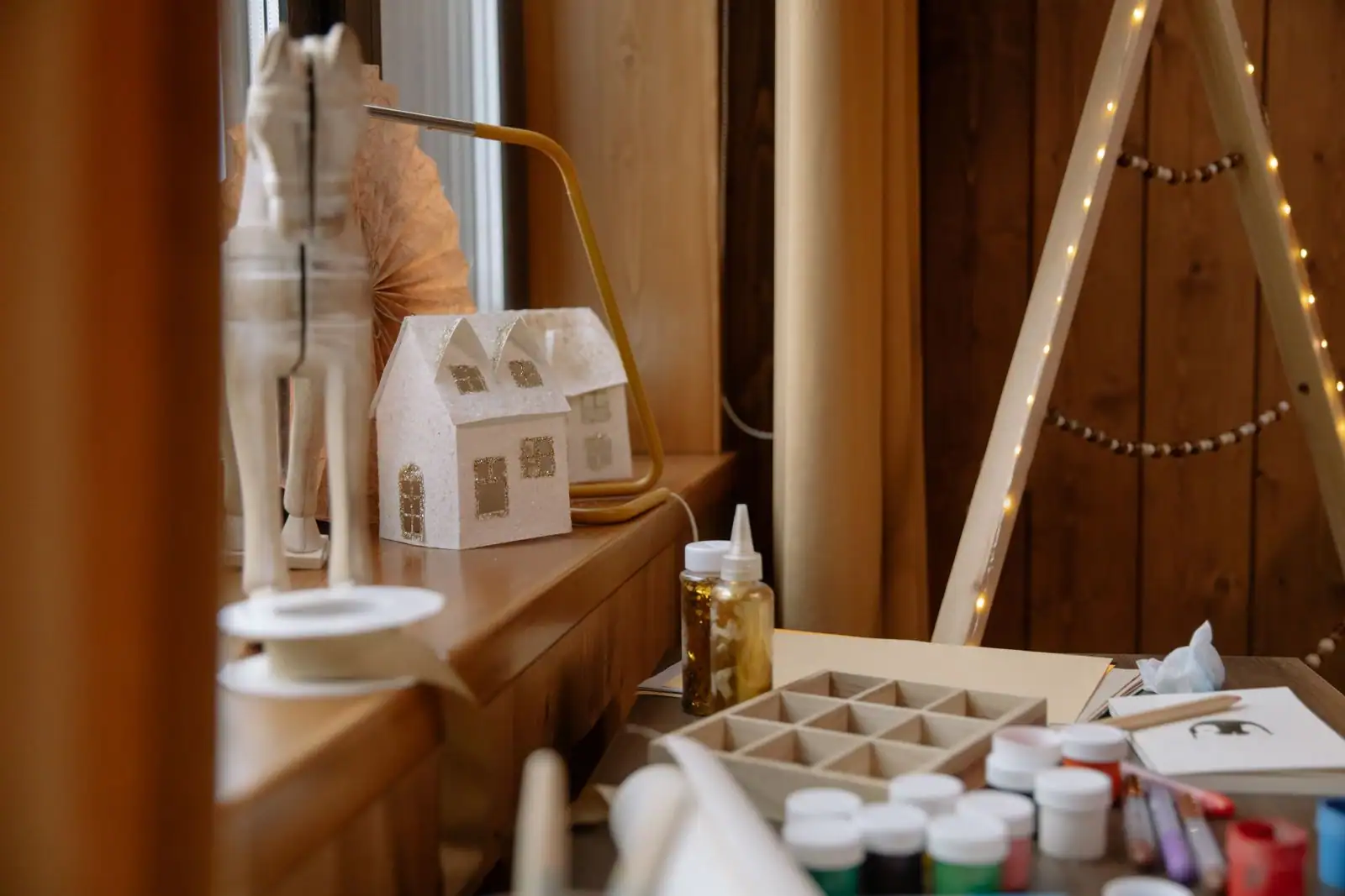 Maison de Noël en papier et fournitures de bricolage, peinture et colle, sur un plan de travail