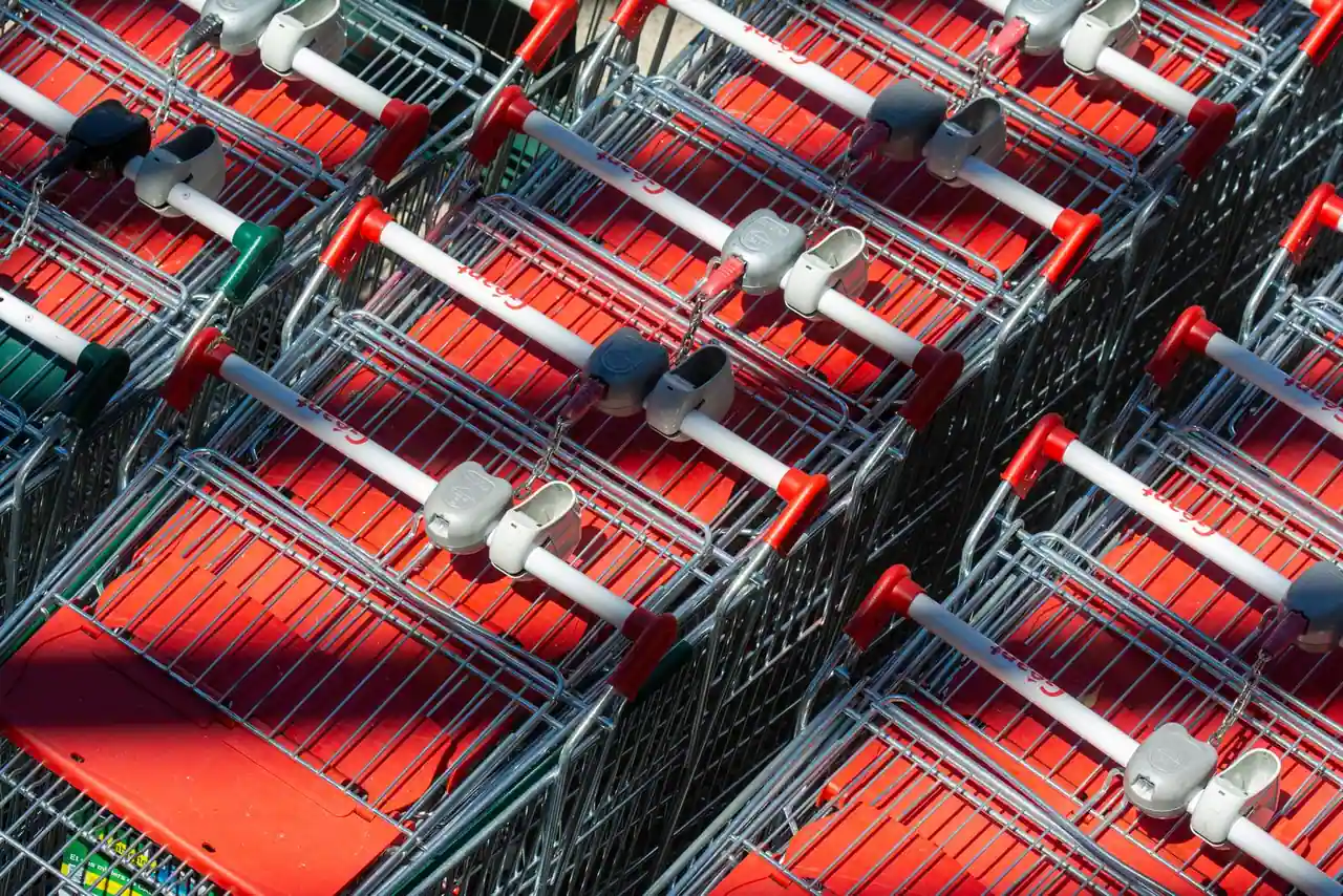 Chariots de supermarché rouges imbriqués les uns dans les autres, en gros plan au soleil