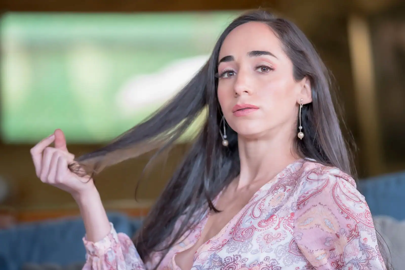 Femme tenant une mèche de ses longs cheveux bruns