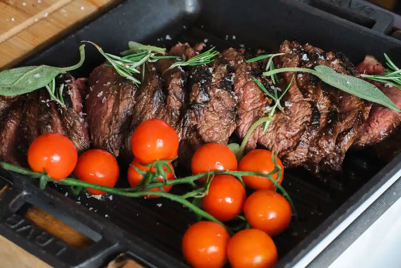 Steak grillé tranché dans une poêle-gril en fonte, son cœur encore rosé visible