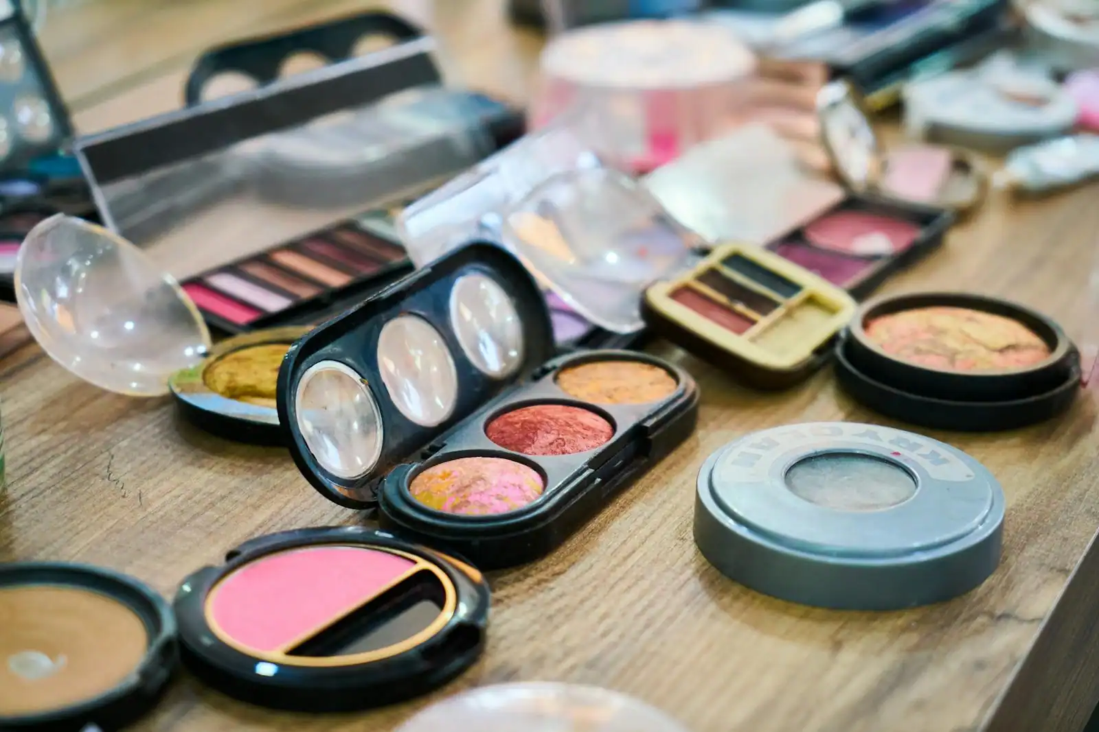 Produits de maquillage colorés et abordables disposés sur une coiffeuse claire.