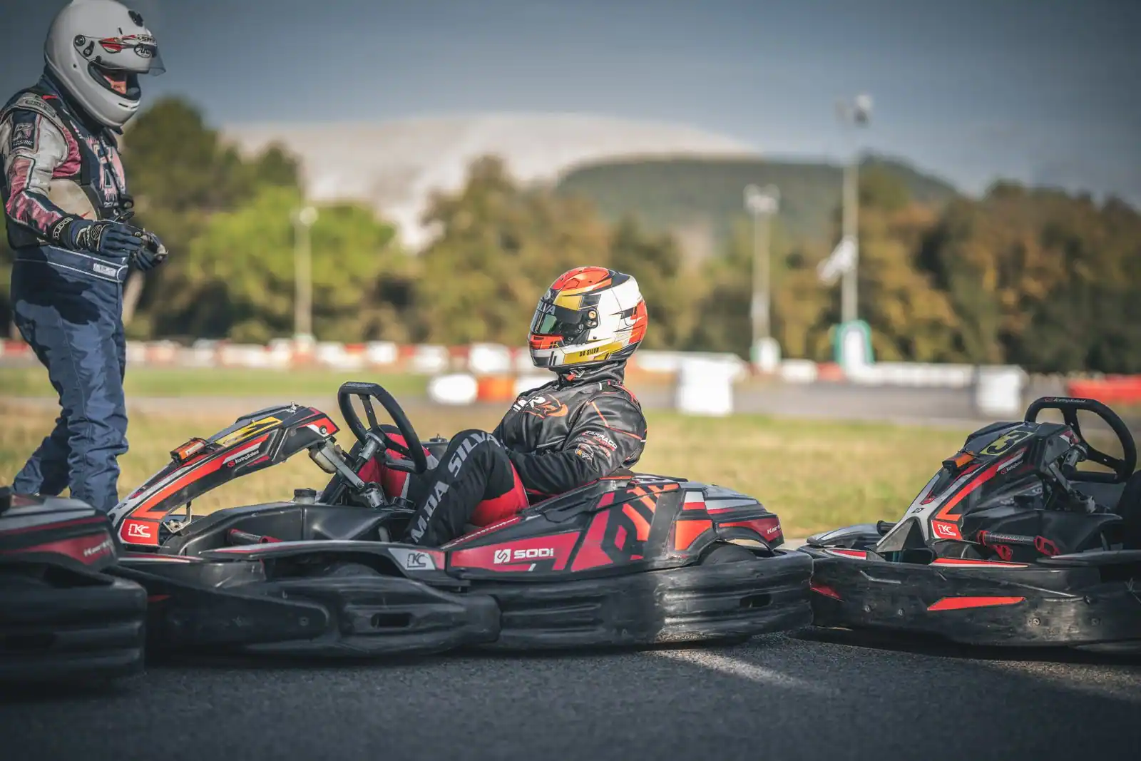 Karts de loisir sur une piste en plein air, un pilote casqué installé dans son kart