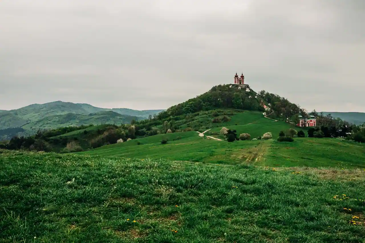 Église chrétienne sur une colline verdoyante, dans un paysage de collines vallonnées
