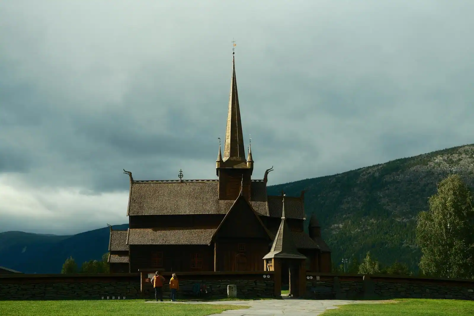 Église en bois debout (stavkirke) norvégienne devant un paysage de montagnes