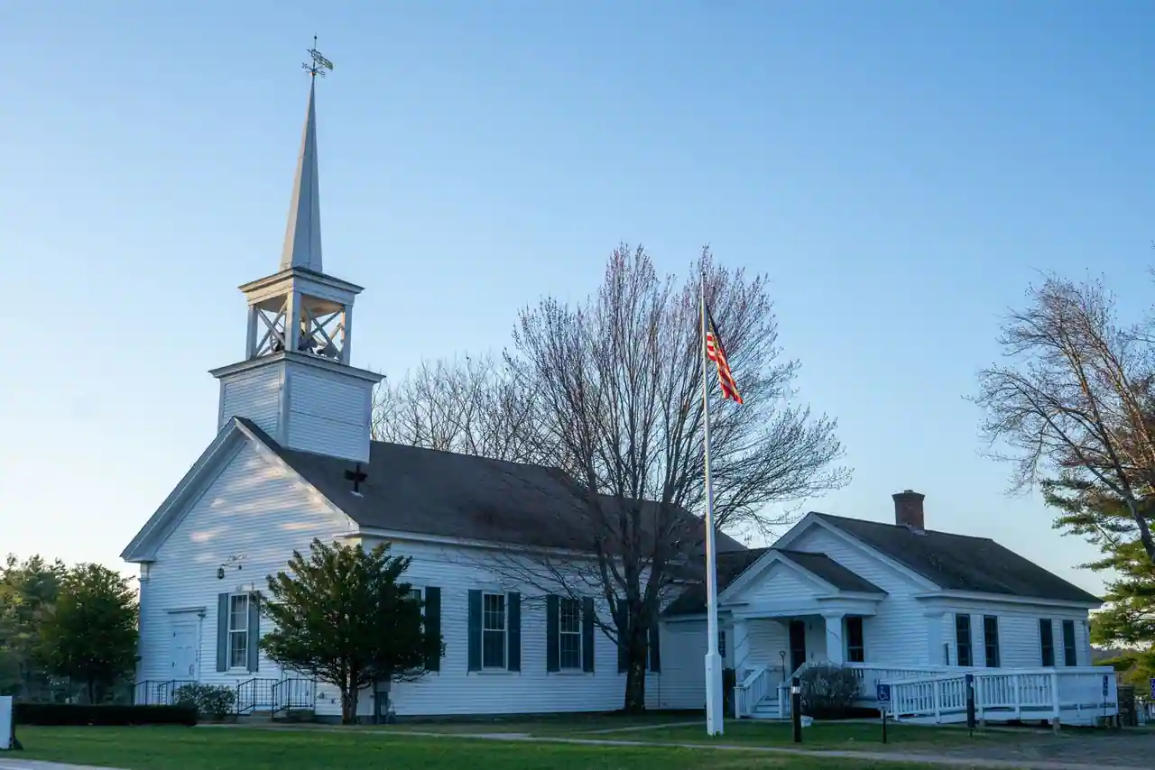 Église américaine en bois blanc surmontée d'une flèche, devant un ciel dégagé