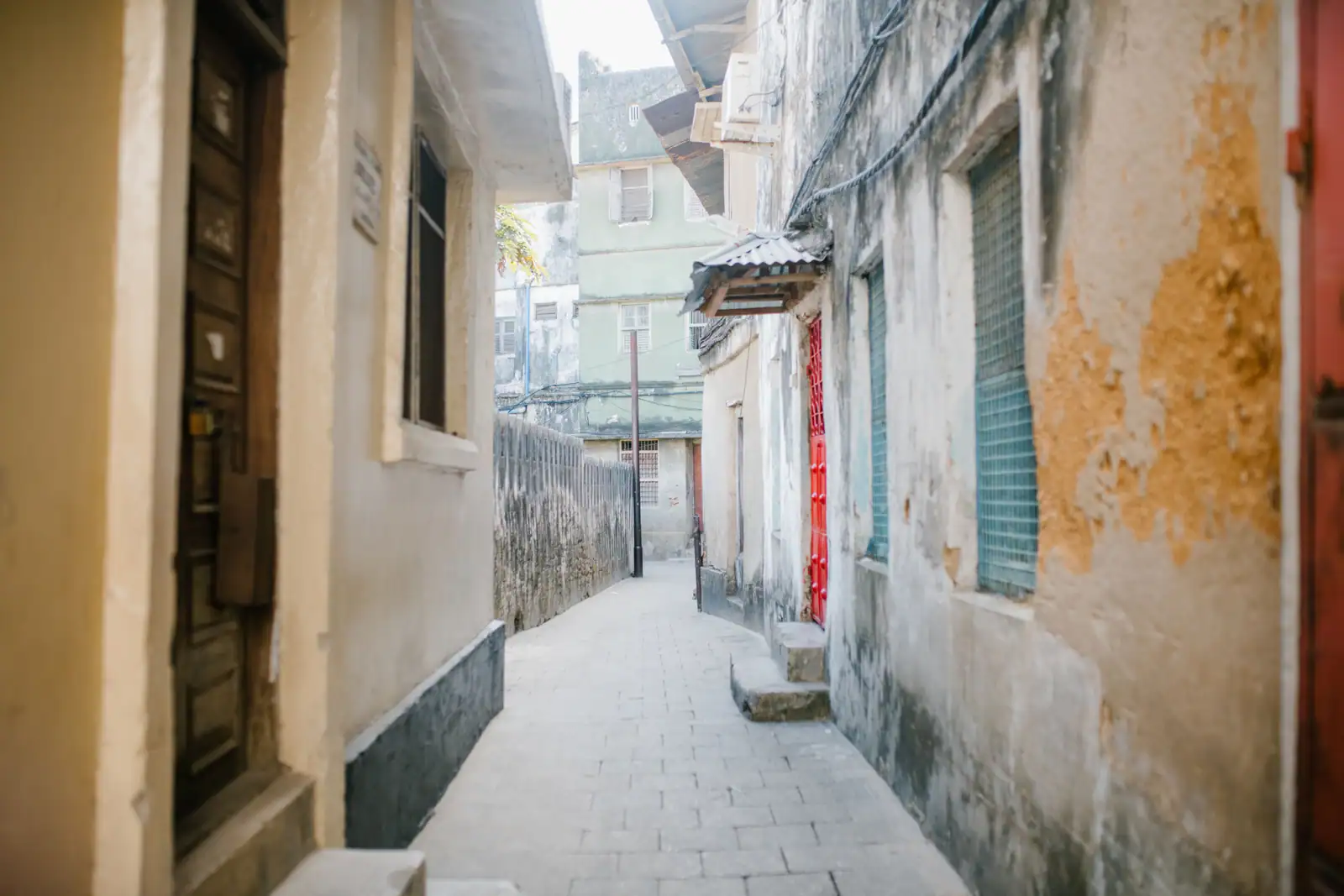 Ruelle de la vieille ville de Stone Town, à Zanzibar, bordée de maisons de pierre anciennes.