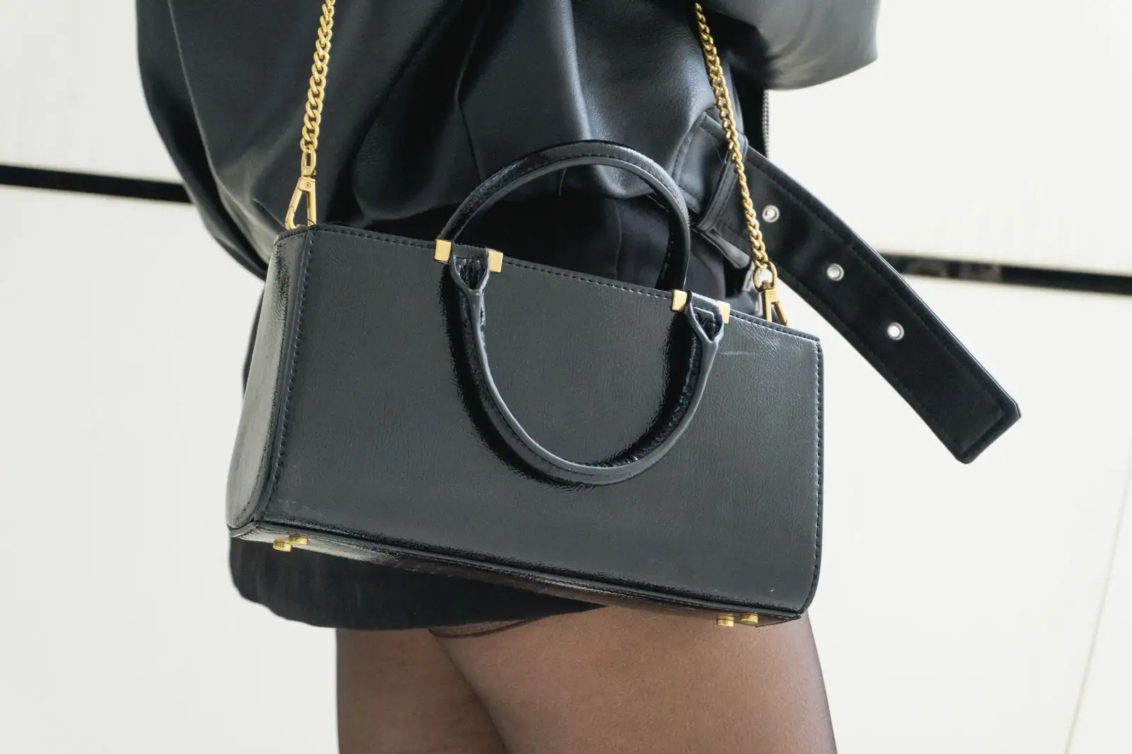 Sac à main en cuir grainé posé élégamment, finitions et chaîne dorée visibles en gros plan
