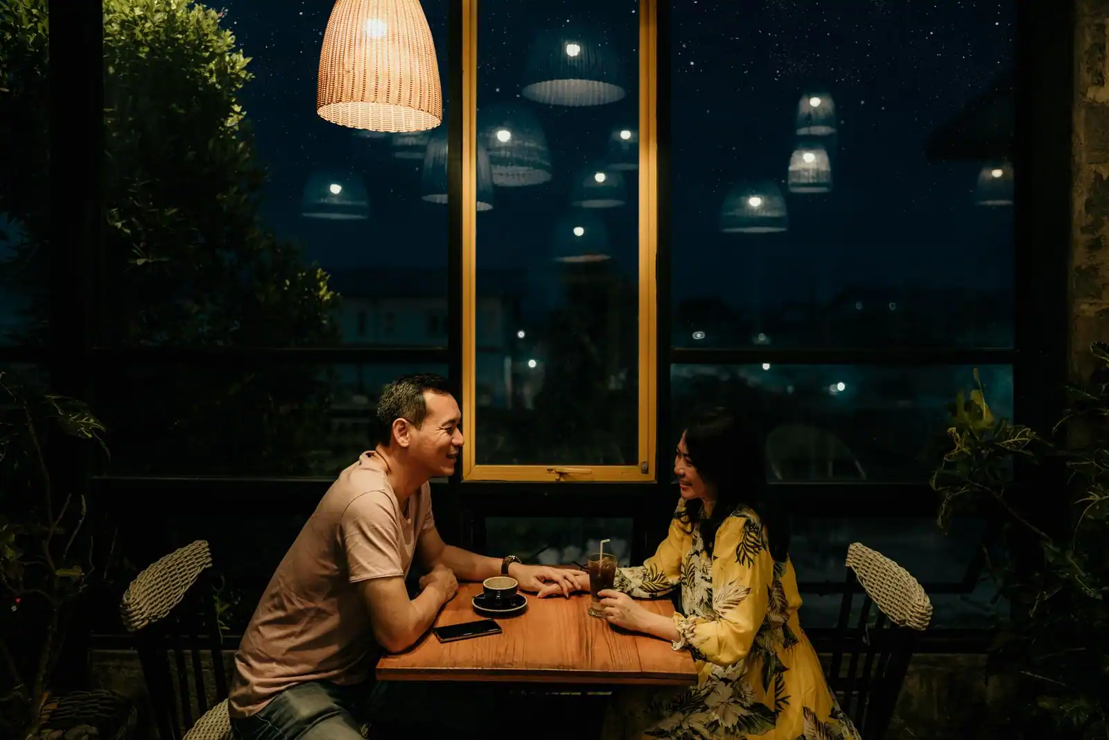Un couple en pleine conversation à la lueur du soir, dans une ambiance intime et complice