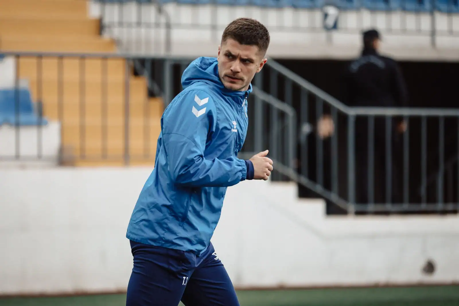 Sportif en tenue de sport technique superposée, prêt pour une séance en extérieur