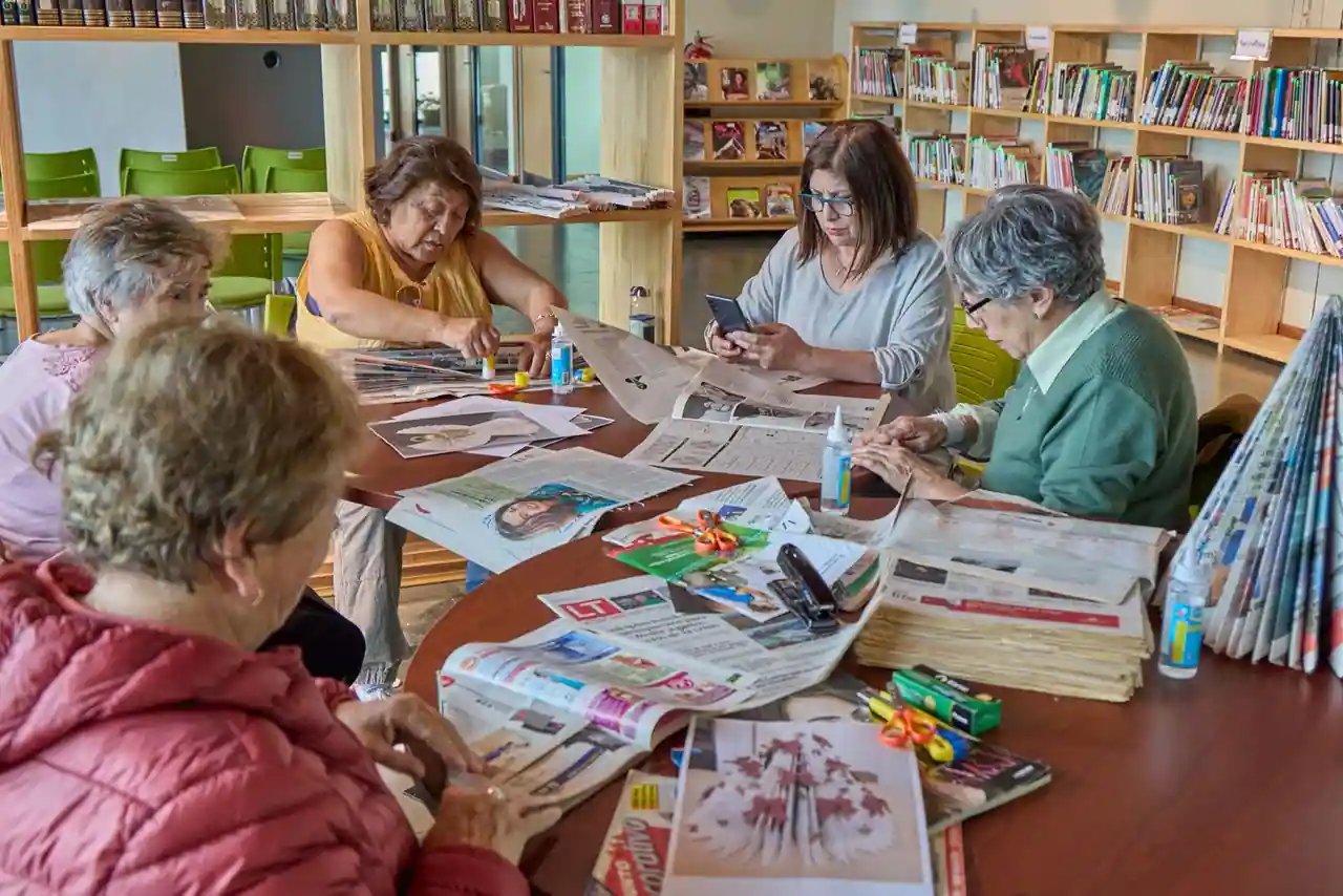 Groupe d'adultes réunis autour d'une activité créative conviviale dans une salle associative.