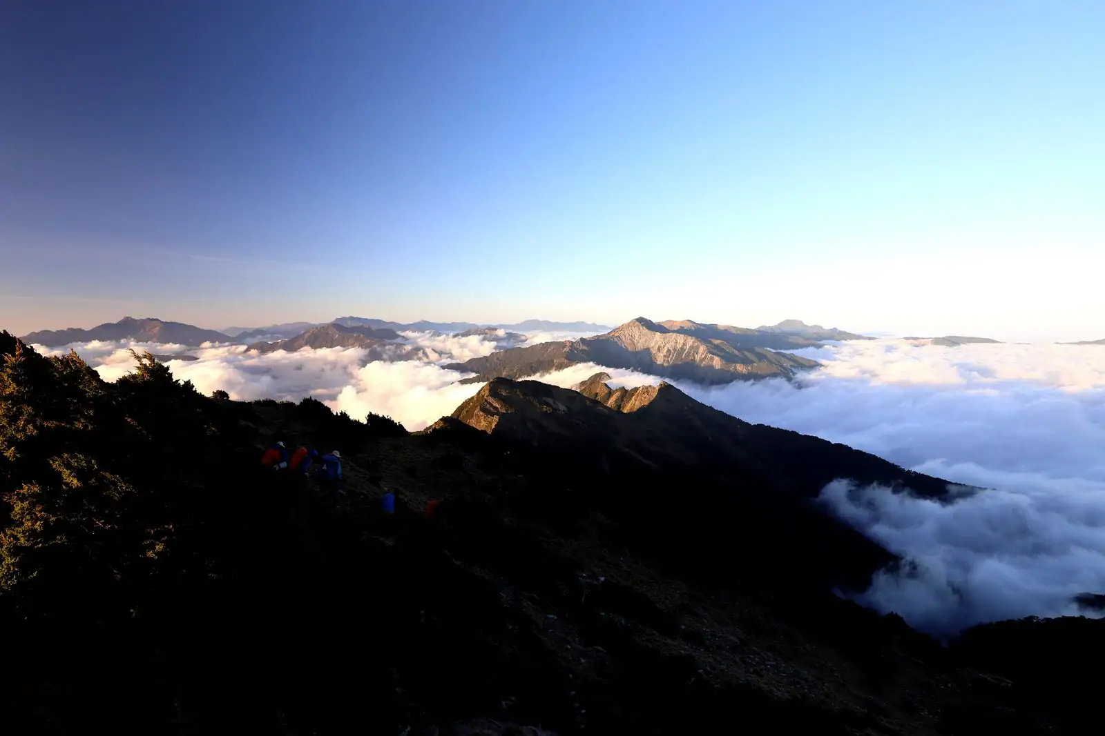 Sommet de montagne calme émergeant d'une mer de nuages au lever du jour