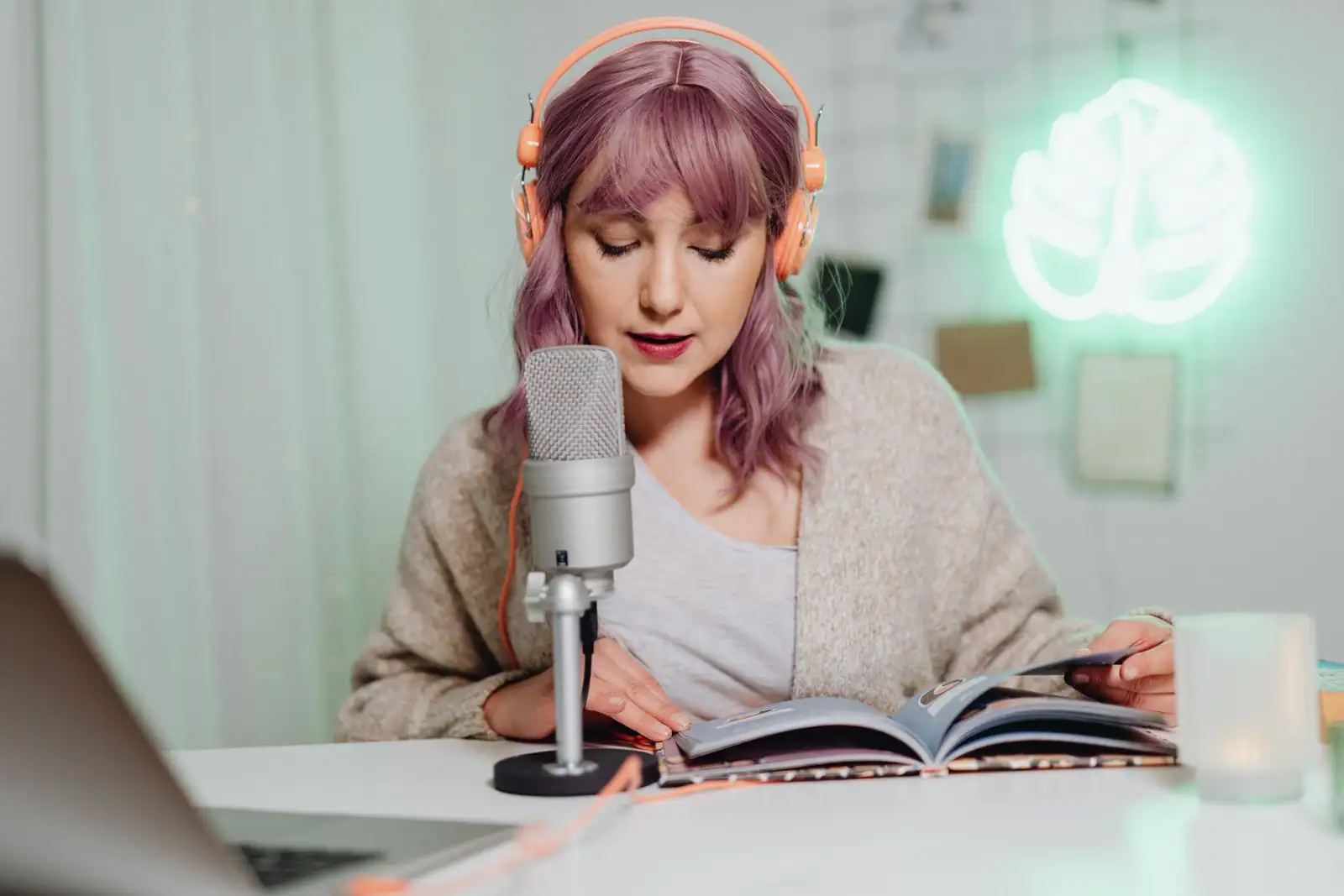 Femme au casque devant un micro de studio, dans une ambiance d'enregistrement radio et de lecture.
