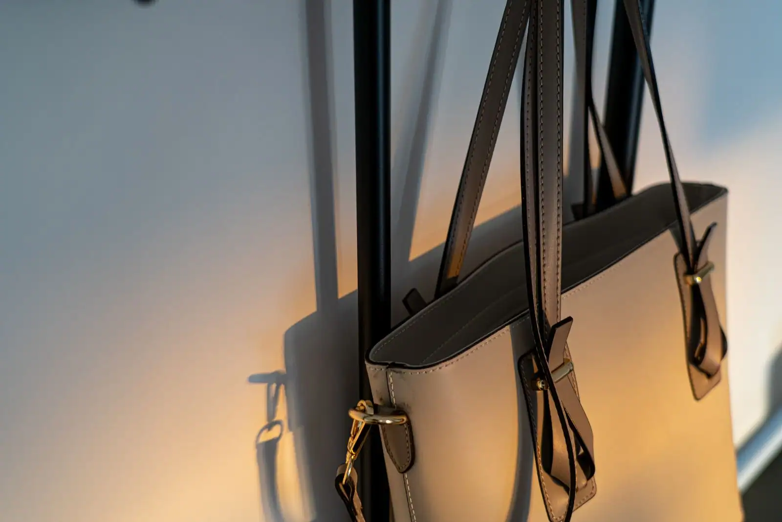 Un sac à main en cuir présenté comme accessoire de mode, aux anses et fermoir soignés.