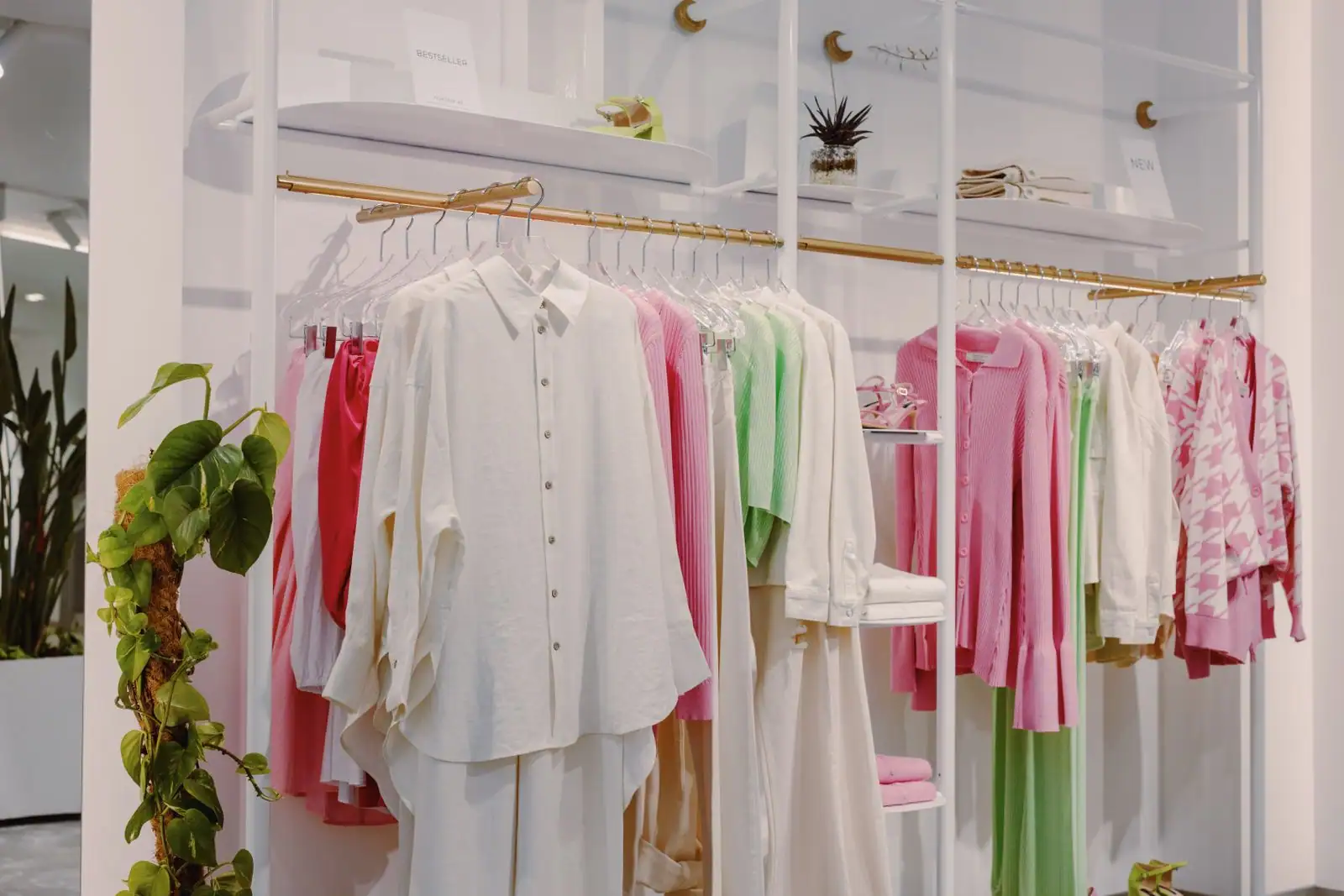 Un portant de vêtements aux pièces soigneusement suspendues, dans une boutique de mode.