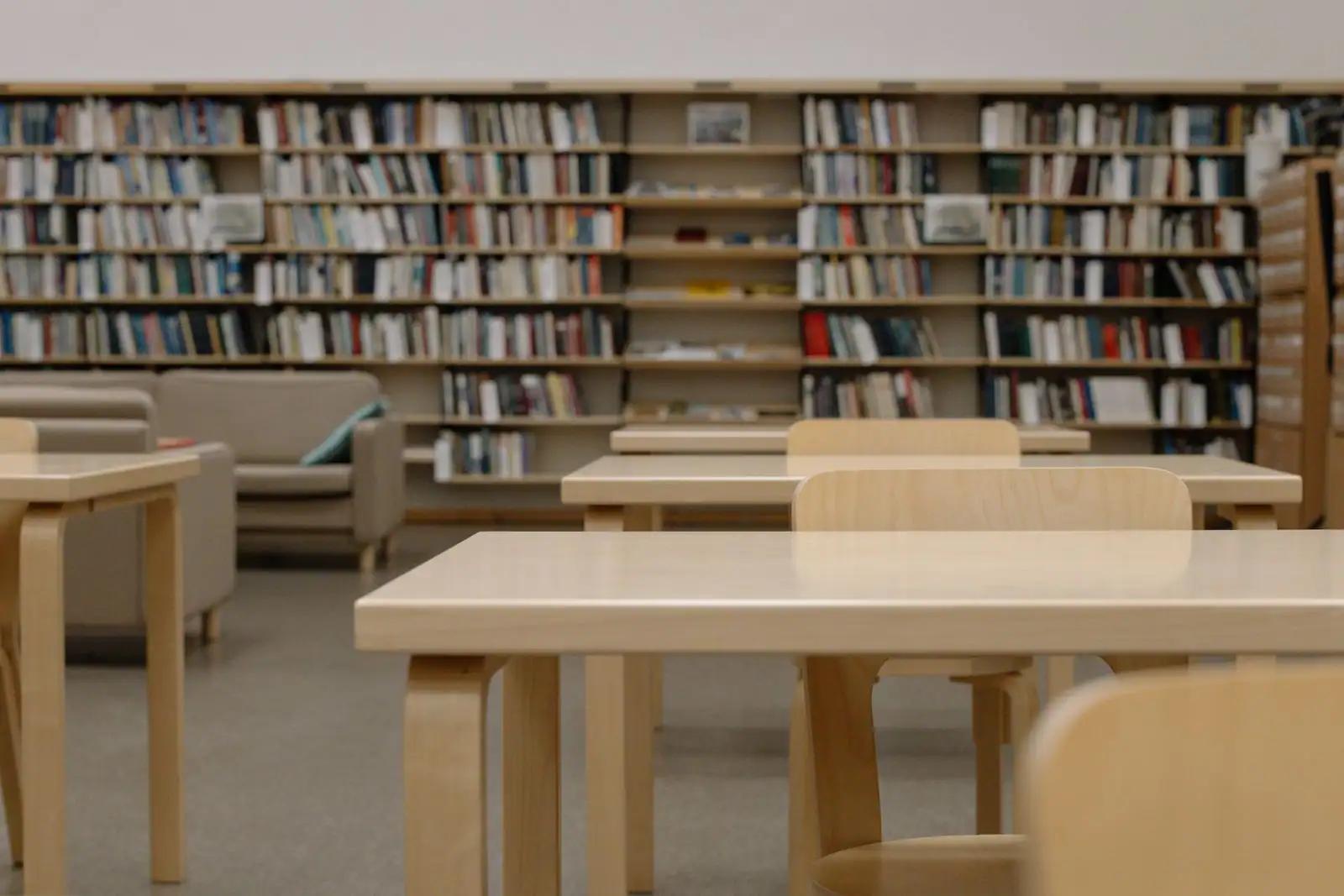 Bibliothèque conviviale aux étagères en bois chargées de livres, ambiance calme et chaleureuse.