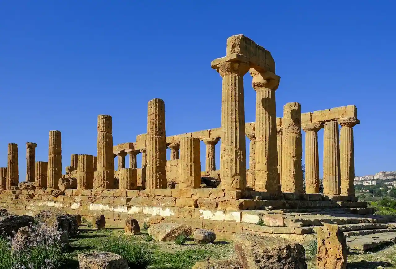 Colonnes de pierre en ruines d'un temple antique grec, vestiges archéologiques sous le ciel.